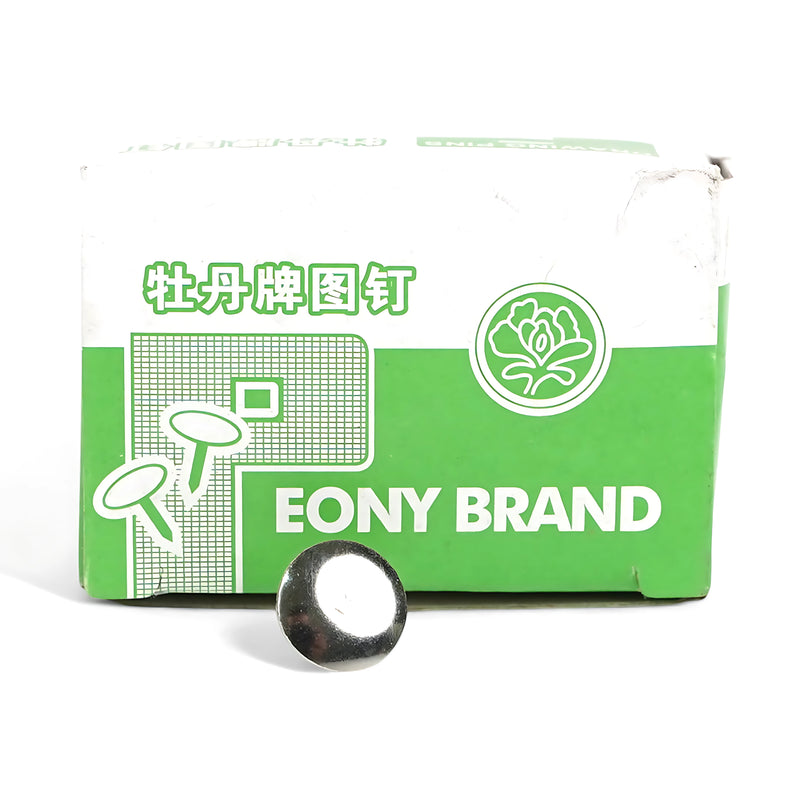 A green and white box of Eony Brand Drawing Pins with one silver pin placed in front, showcasing the product's durable design.

