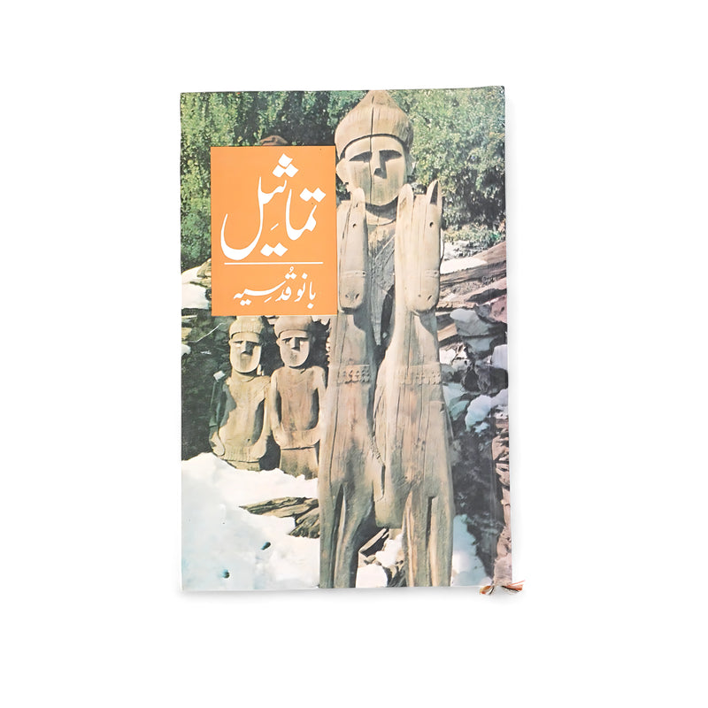 Cover of Tamaseel by Bano Qudsia featuring wooden sculptures set against a natural background, with an orange title box.

